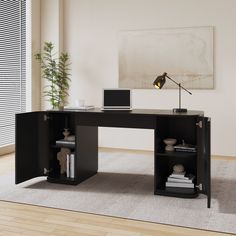 an office desk with a laptop on it in front of a painting and potted plant