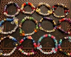 several bracelets are arranged on a table with an intricate design in the middle and colorful beads around them