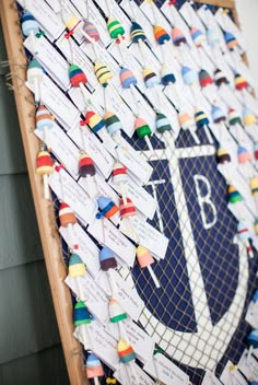 a bulletin board covered in lots of different types of pins and paper with name tags attached to it