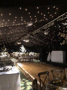 a banquet hall with tables and chairs covered in lights