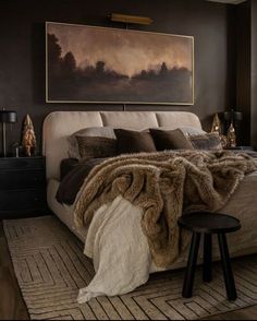 a bedroom with a large painting on the wall and a bed covered in furs