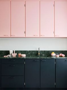 a kitchen with pink cabinets and marble counter tops