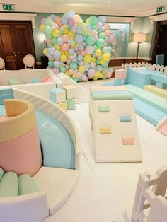 a room filled with lots of different colored balloons and furniture on top of white flooring