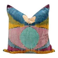 a multicolored pillow with a decorative design on the front and back, sitting on a white background