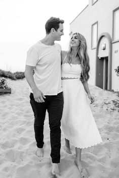 a man and woman walking in the sand together