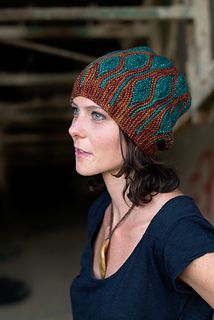 a woman wearing a knitted hat looking off into the distance with her hand on her hip