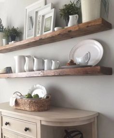 two wooden shelves above a table with plates and bowls on it, one shelf holding dishes