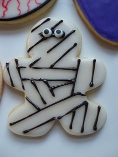 decorated cookies with black icing and eyes on them