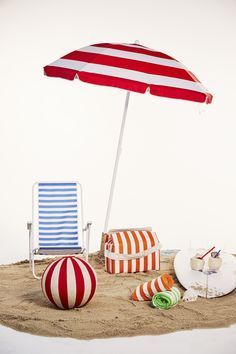 an umbrella and beach chairs on the sand