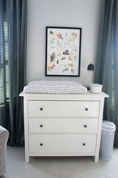 a baby's crib in the corner of a room with curtains on the window