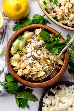 two bowls filled with food next to lemons and mint leaves on a table top