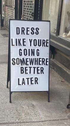 a sign on the sidewalk that says dress like you're going somewhere better later