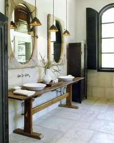 a bathroom with two sinks and mirrors on the wall