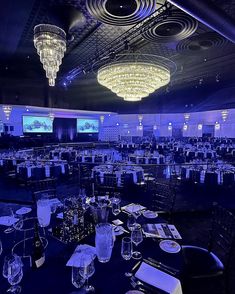 an empty banquet room is lit up with chandeliers and place settings for dinner
