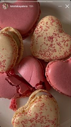 heart shaped pastries on a plate with red sprinkles and white frosting