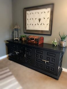 a room with a large black cabinet and pictures on the wall