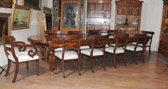 a dining room table and chairs in an old fashioned house with paintings on the wall