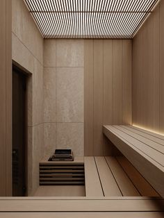 a wooden bench sitting in front of a wall next to a doorway with a phone on it