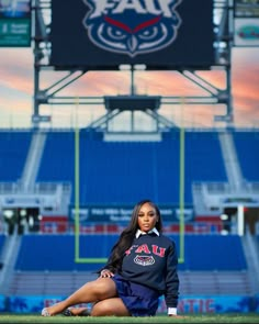 a woman sitting on the sidelines of a football stadium