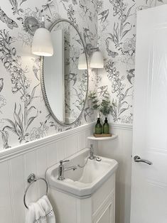 a white sink sitting under a bathroom mirror