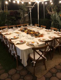 an outdoor dining table set up with plates and utensils for the guests to eat