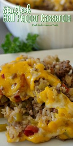 a white plate topped with meat and cheese covered casserole on top of rice