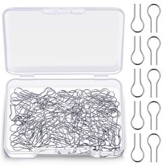 a plastic container filled with lots of silver colored paper clips and some black metal scissors