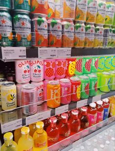 many different types of drinks on display in a store