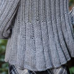 the back of a woman's sweater that is knitted in grey and black