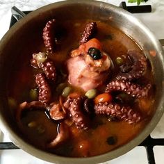 an octopus stew is shown in a pan on the stove