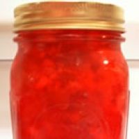 a jar filled with red liquid sitting on top of a table