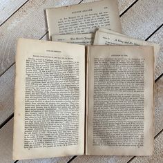 three old books sitting on top of a wooden table