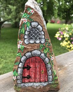 a rock with a red door painted on it sitting on top of a wooden table