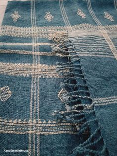 a blue and white checkered blanket laying on top of a bed