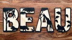 the word beau is made up of wood and metal with silhouettes of animals