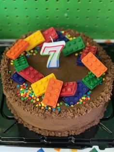 a birthday cake decorated with legos and the number seven on it's chocolate frosting