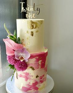 a three tiered cake with pink flowers on top and the words twenty one above it