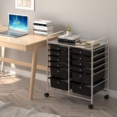 a laptop computer sitting on top of a wooden desk next to a stack of books