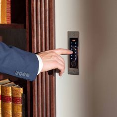 a person in a suit is pressing the button on a door handle with his finger