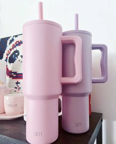 two pink tumblers sitting next to each other on a table