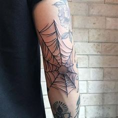 a man with a spider web tattoo on his arm