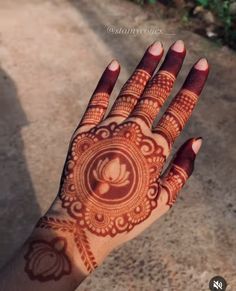 the hand is decorated with henna designs and has a circular design on it's palm