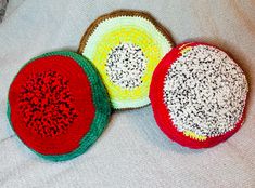 three crocheted baskets sitting on top of a white bed next to each other