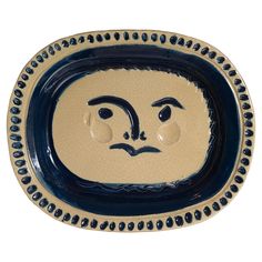 a blue and white plate with an image of a face on the inside of it