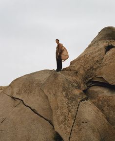 a man standing on top of a large rock