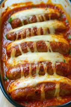 four stuffed meatballs in a casserole dish with melted cheese on the top