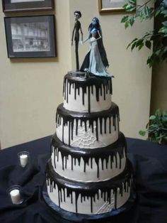 a wedding cake is decorated with black and white icing dripping from the top, while a bride and groom are standing on top