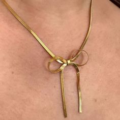 Unleash your wild side with the Lily Bow Necklace. This unique snake chain necklace features a playful, feminine bow design that will add a touch of quirkiness to any outfit. Perfect for the fashion-forward trendsetter, this necklace is sure to make a statement. 18k Gold Plated Over Stainless Steel Hypoallergenic Water & Tarnish Resistant Elegant Gold Necklace With Decorative Bow, Adjustable Necklace With Decorative Bow For Party, Gold Bow Necklace For Party, Gold Necklace With Bow For Party, Chic Jewelry With Butterfly Knot For Parties, Adjustable Necklace With Decorative Bow, Chic Party Jewelry With Butterfly Knot, Bow Choker Jewelry For Parties, Trendy Delicate Snake Chain Necklace Gift