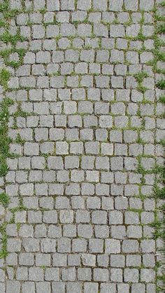 an overhead view of a brick sidewalk with grass growing on it