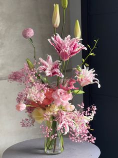 a vase filled with pink flowers on top of a table